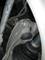 A close-up of part of a vehicle's suspension. Visible are bolts, fastening components, and a drive shaft.
