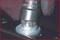 'Anti-rotation nut' with a damaged screw head and an attached rubber protective sleeve.