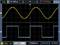 'Oscilloscope screen shows two waveforms: upper yellow sine wave and lower blue square wave. Axes indicate voltages.'