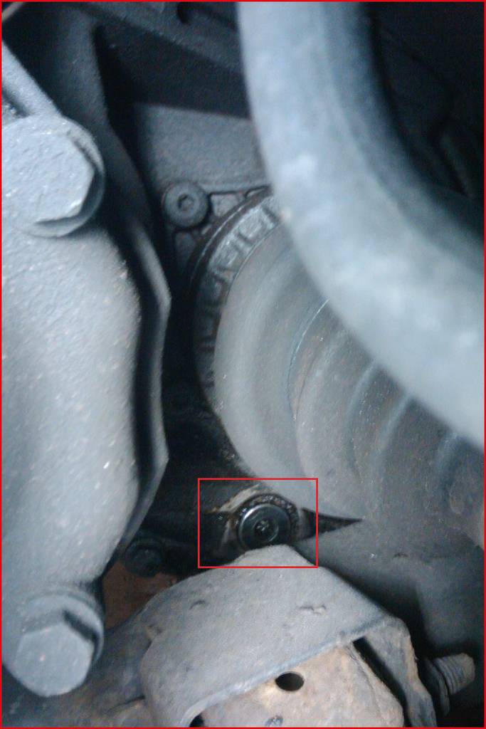 Close-up of a vehicle component showing bolts and an axle. The focus is on the technical detail of a vehicle mechanism.