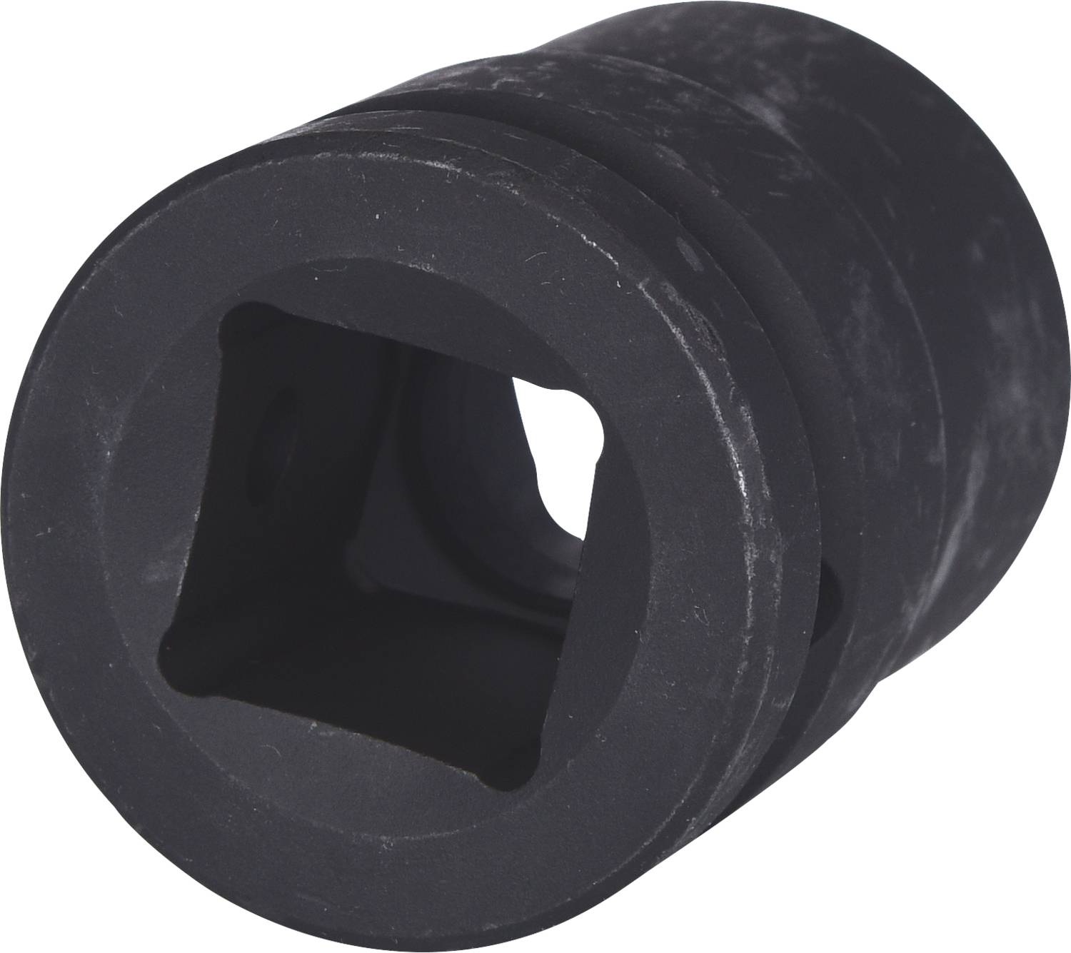 Black cylindrical component with a square opening in the centre, potentially a machine part or adaptor.