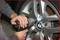 A mechanic tightens the wheel nuts of a BMW tyre with an impact wrench.