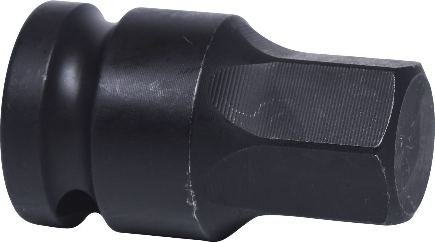 A black, cylindrical metal attachment with grooves, presumably a tool or socket, is lying on its side.