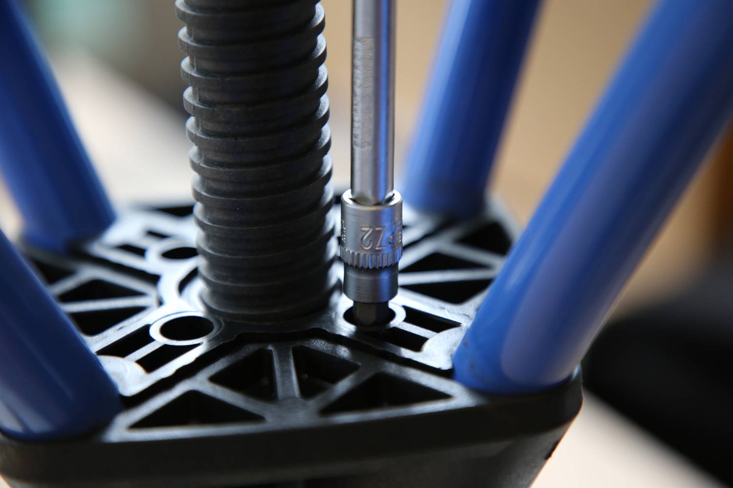 Assembly of a 3D Printer: A screw is being secured with an Allen key to stabilise the blue frame at the base.