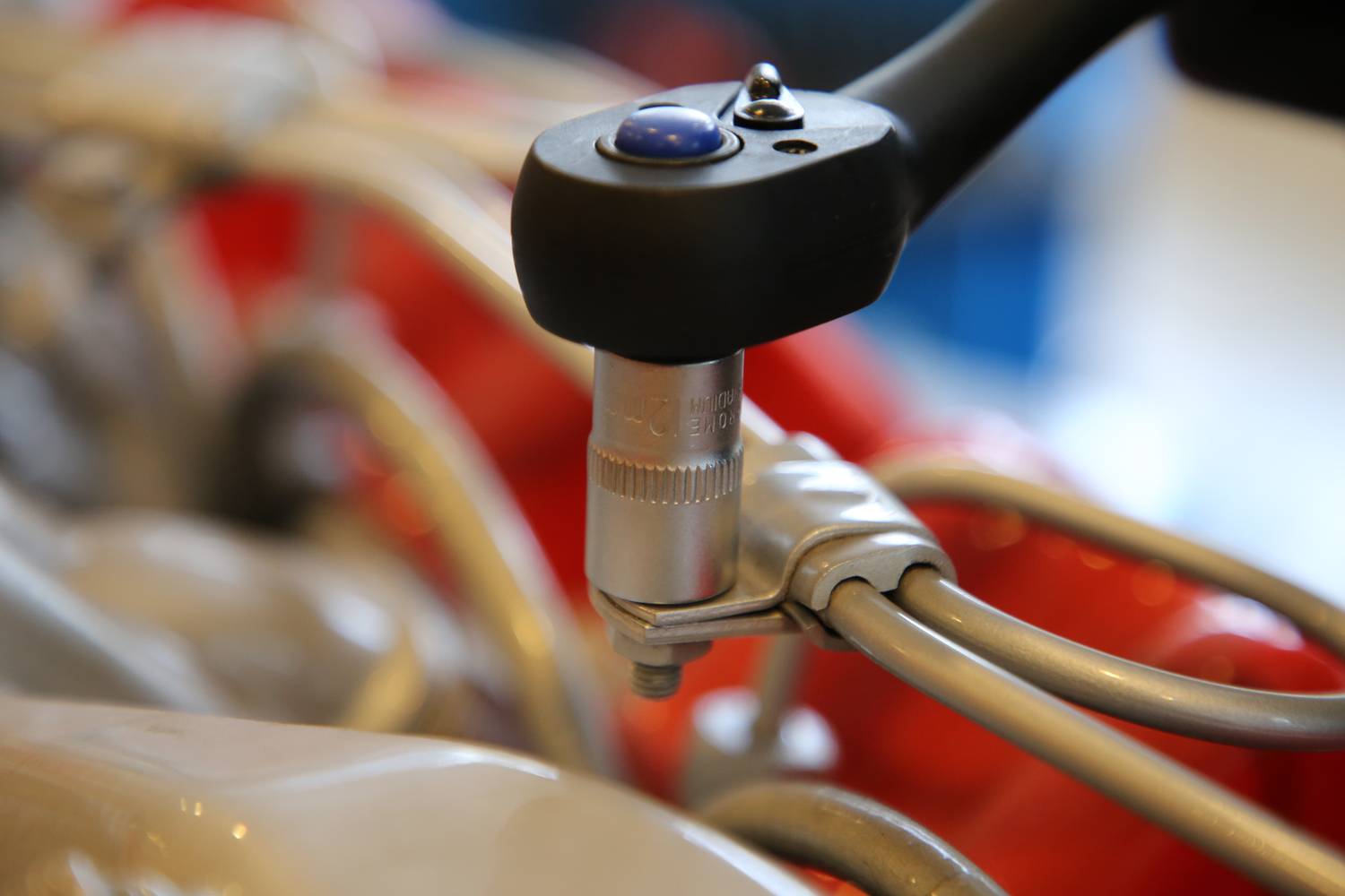 A torque wrench tightens a screw to secure pipes. Close-up shot, focusing on the tool and the screw.