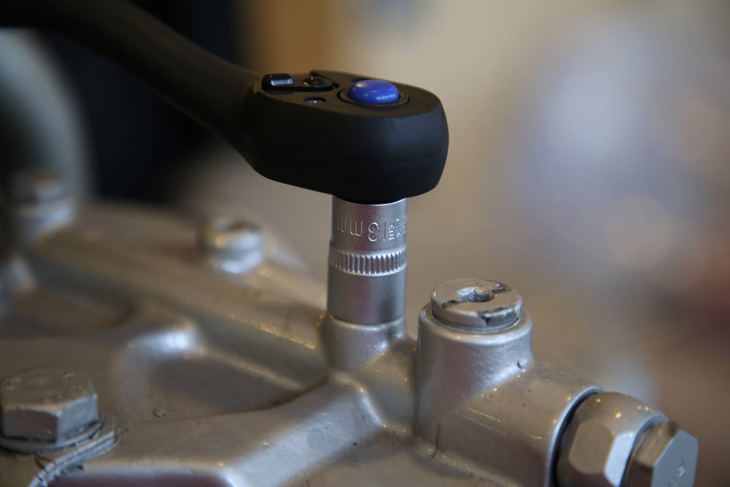 'Ratchet torque wrench tightens screw on metal device.'