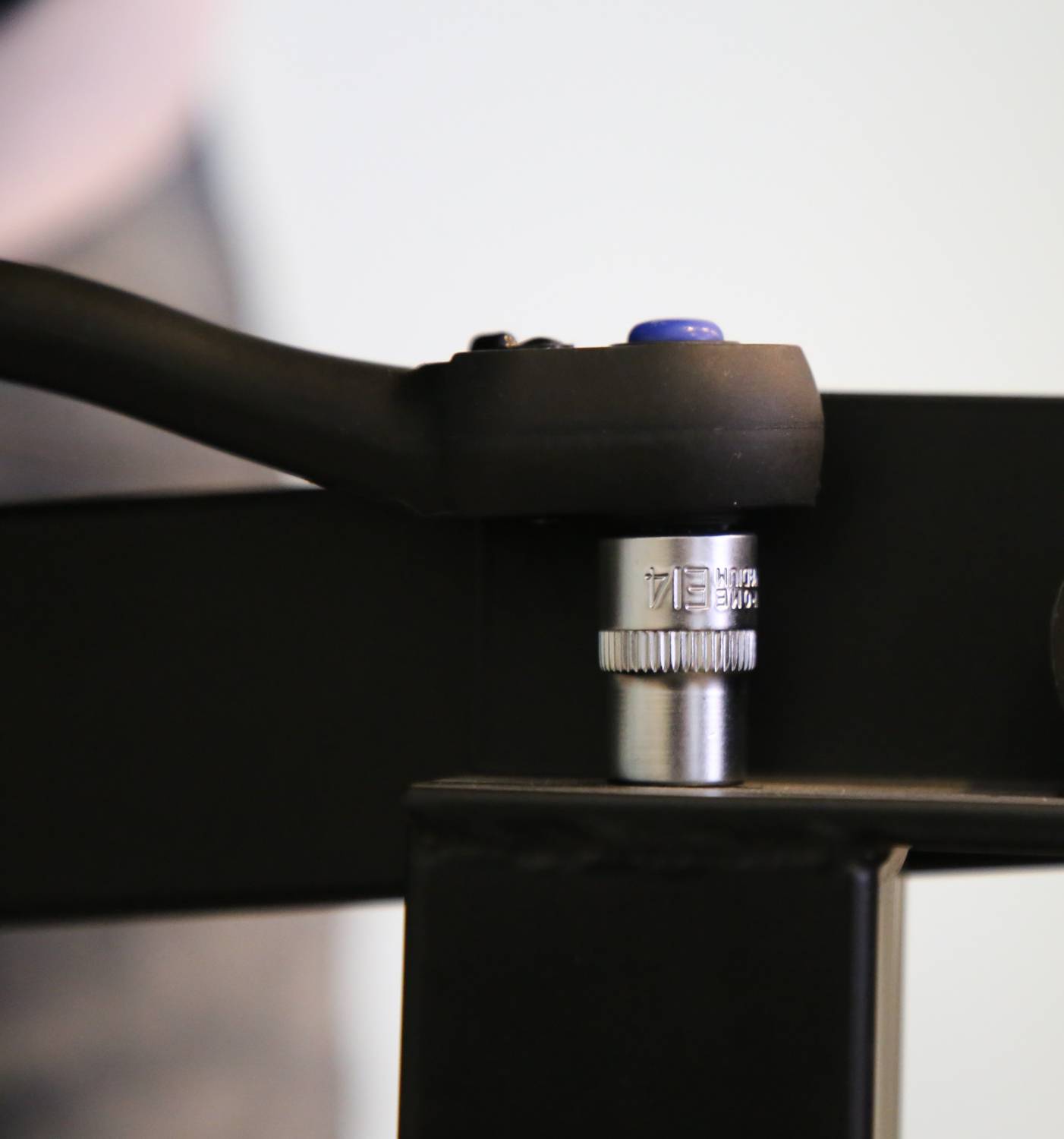 'Close-up of a metal tool with a black-handled lever attached to a black metal frame.'