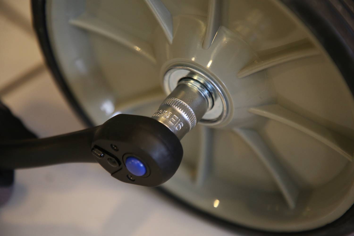 Close-up of an air compressor inflating a tyre. A metal valve cap is visible on the tyre valve.