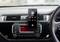 A smartphone is mounted on the dashboard of a car and displays an active call screen. Below it is the car radio.