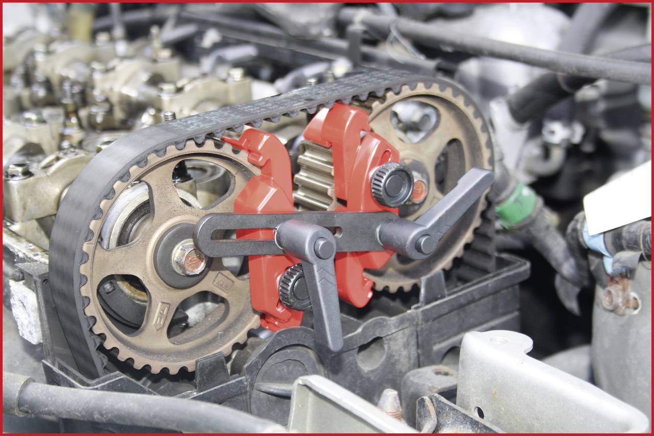 A motor with a visibly installed timing belt that is tensioned using a specialist tool. The motor is partially dismantled.