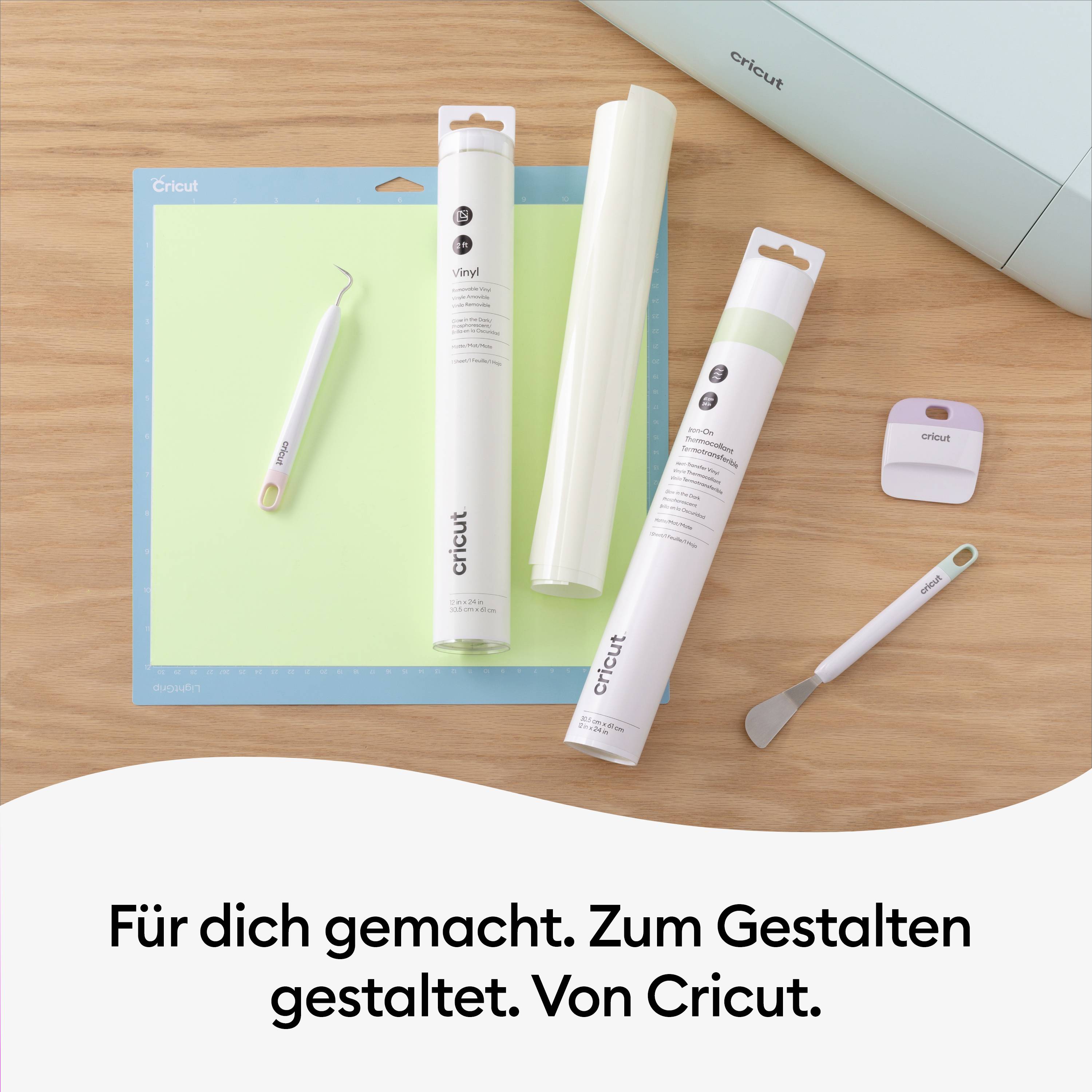 Cricut tools and materials on a table: green cutting mat, vinyl rolls, weeding hook, Cricut Joy and a roller. Text: 'Made for you. Designed to create. By Cricut.'