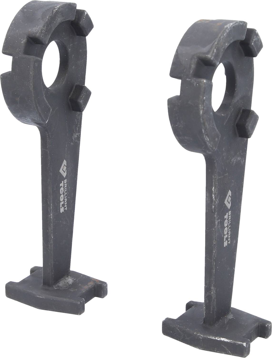 Two dark metal parts with ring-shaped ends and angled supporting feet, standing upright on a light surface.