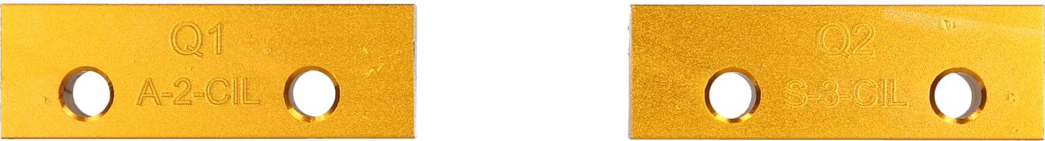 Two yellow metal plates, each with two holes. Left engraved 'Q1 A-2 GL', right 'Q2 B-3 RA'.