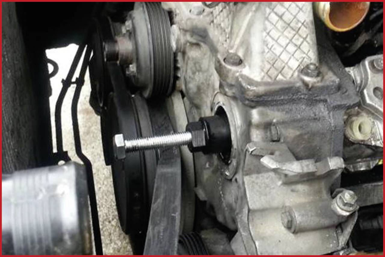 Close-up of a car component showing a bolt in the engine block. The bolt is screwed into an opening, with mechanical details visible.