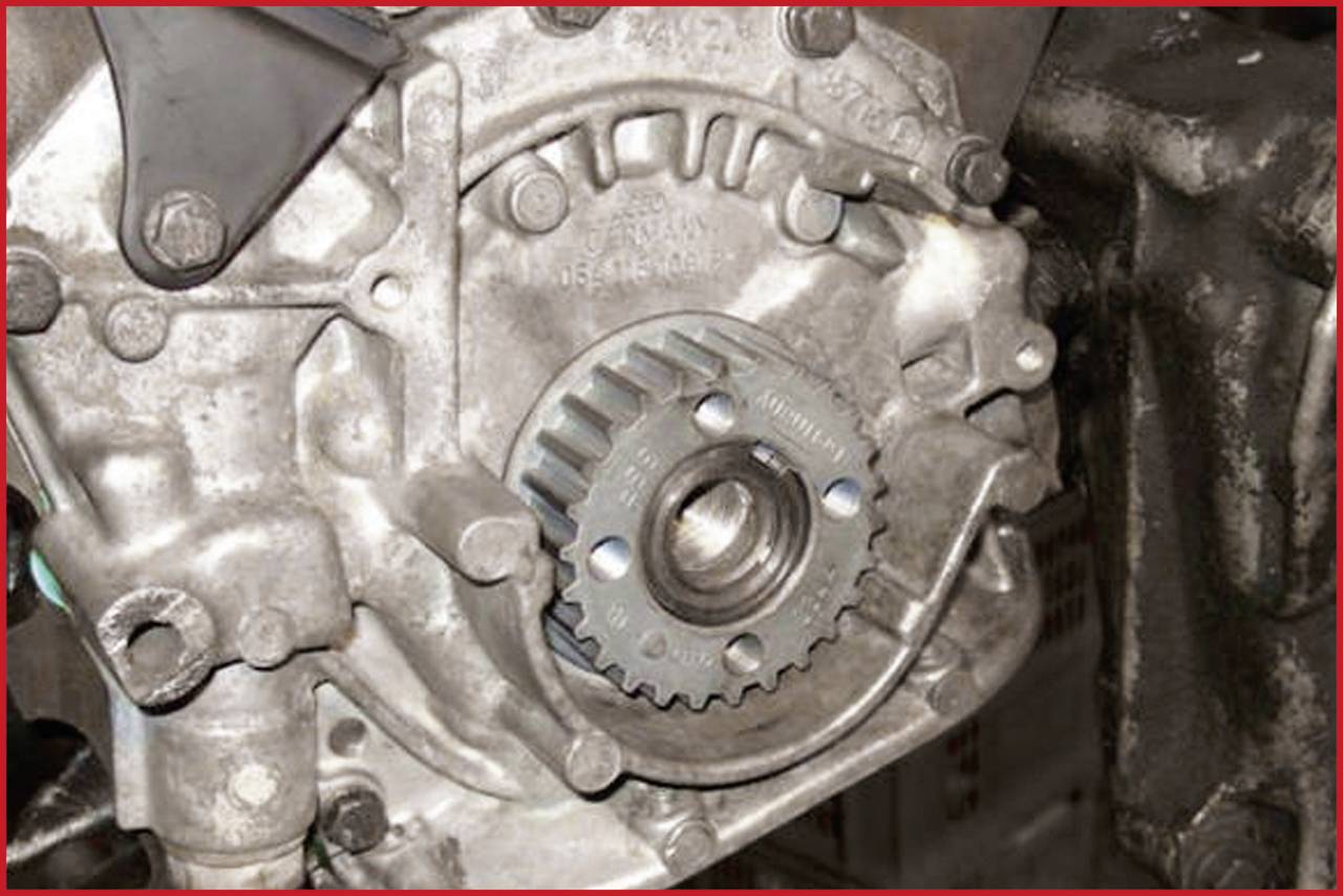 Close-up of a metallic gear component in an engine bay, showing the intricate structure and arrangement of the gears.