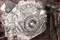 Close-up of a metallic gear component in an engine bay, showing the intricate structure and arrangement of the gears.