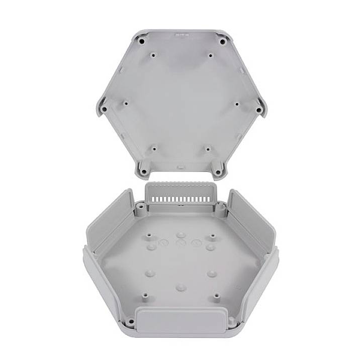 Hexagonal grey plastic box with a removable lid. The box has raised edges and circular recesses in the base. Suitable for assembly purposes.