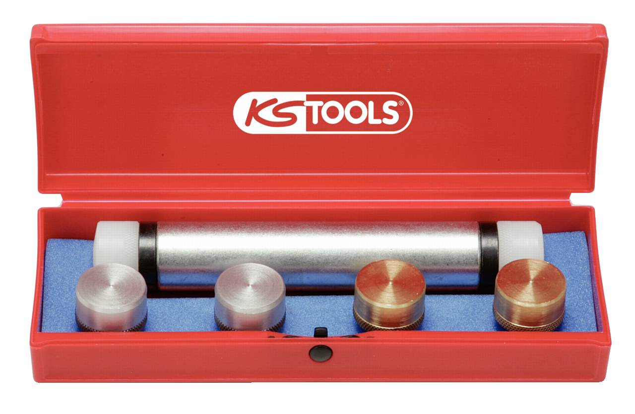 A red toolset with five metal elements: a cylindrical tool in the centre, surrounded by four round brass and aluminium inserts, set in a foam lining.