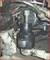 A puller is used to remove a ball joint from an automotive component. The connections are covered in dirt.