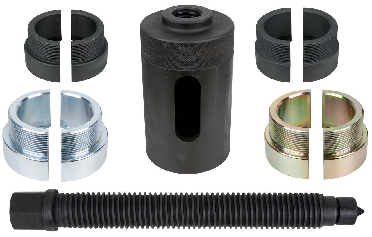 Parts of an axle assembly tool kit: central cylinder, screws, various adapters in metal and plastic finishes.