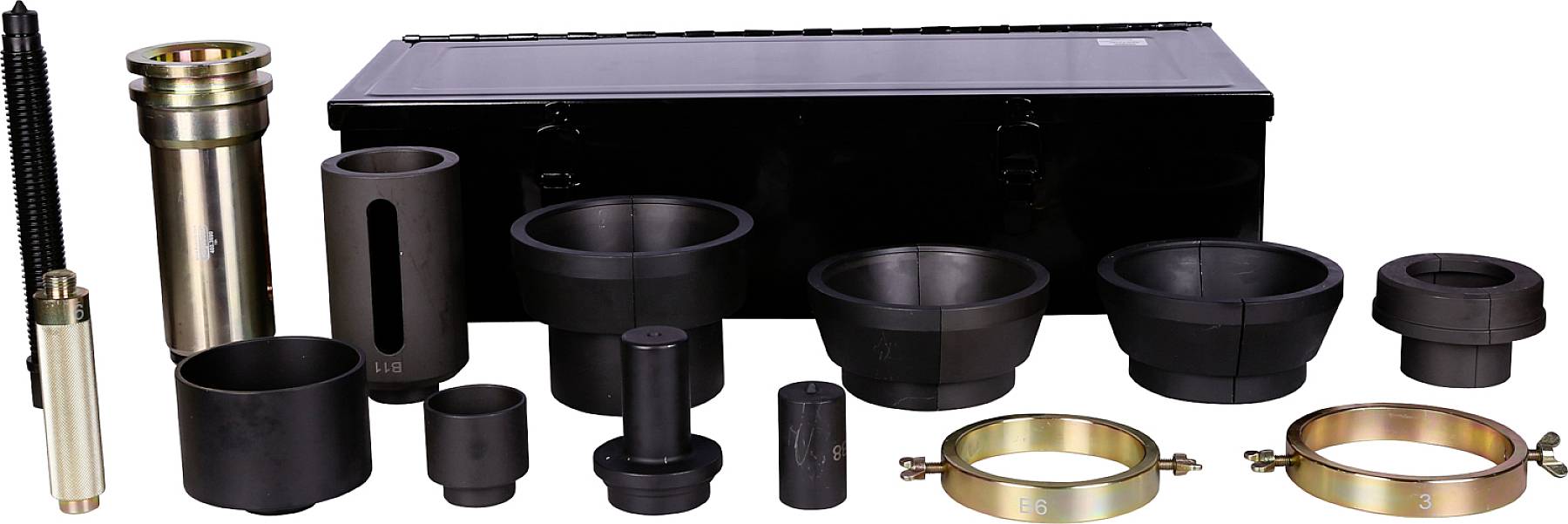 Various black and gold engineering components laid out in front of a black tool case.