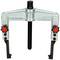 A metal puller tool with two adjustable arms and a central threaded screw for removing bearings or gears.