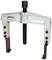 A two-legged metal puller with a threaded centre and two adjustable arms for removing bearings or gears.