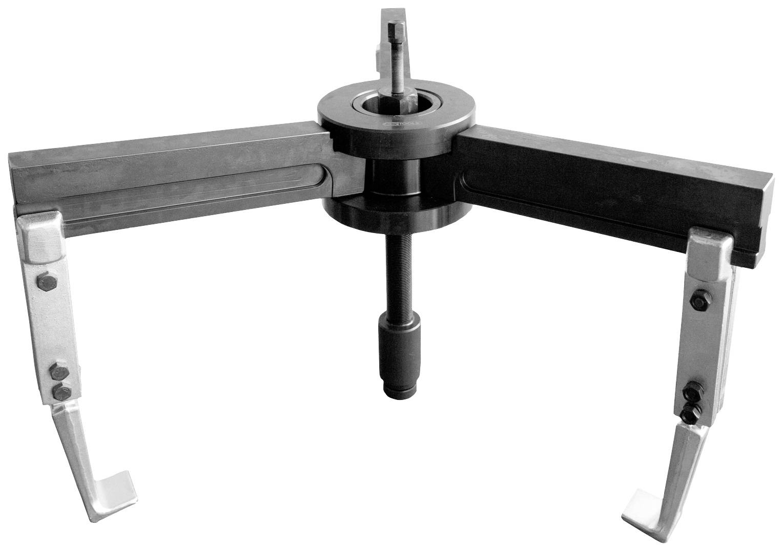 A black-and-white photograph of a two-armed bearing puller, opening to remove a bearing from a shaft.