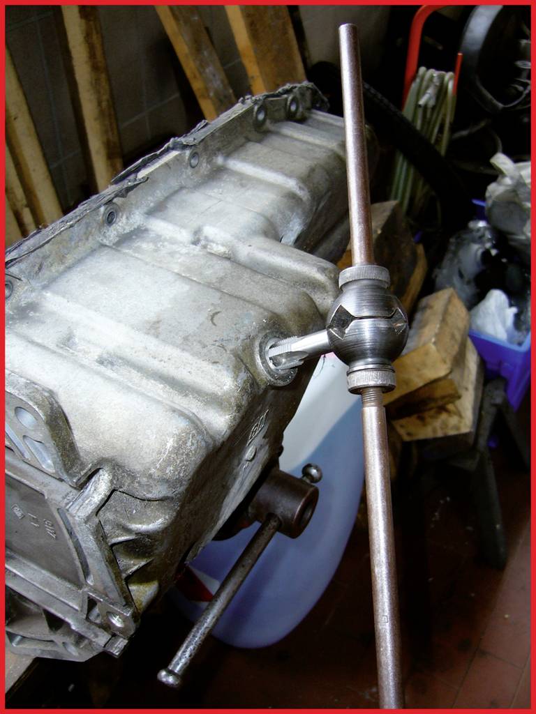 A clutch housing is being repaired. A thread-cutting tap is being used to cut a new thread into the worn component.