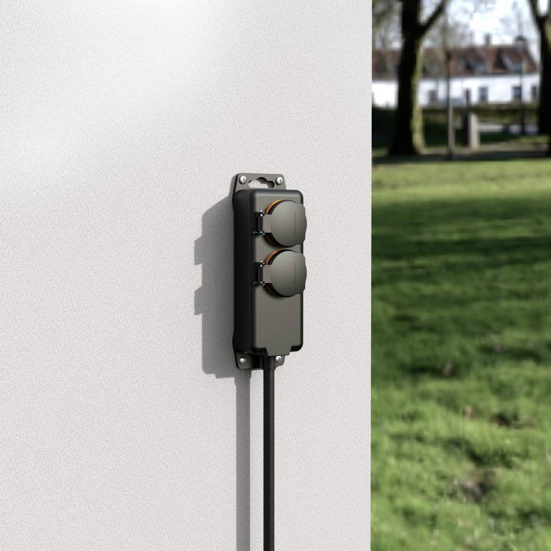 Outdoor electrical socket on a white wall with two plug sockets, surrounded by green lawn and trees in the background.