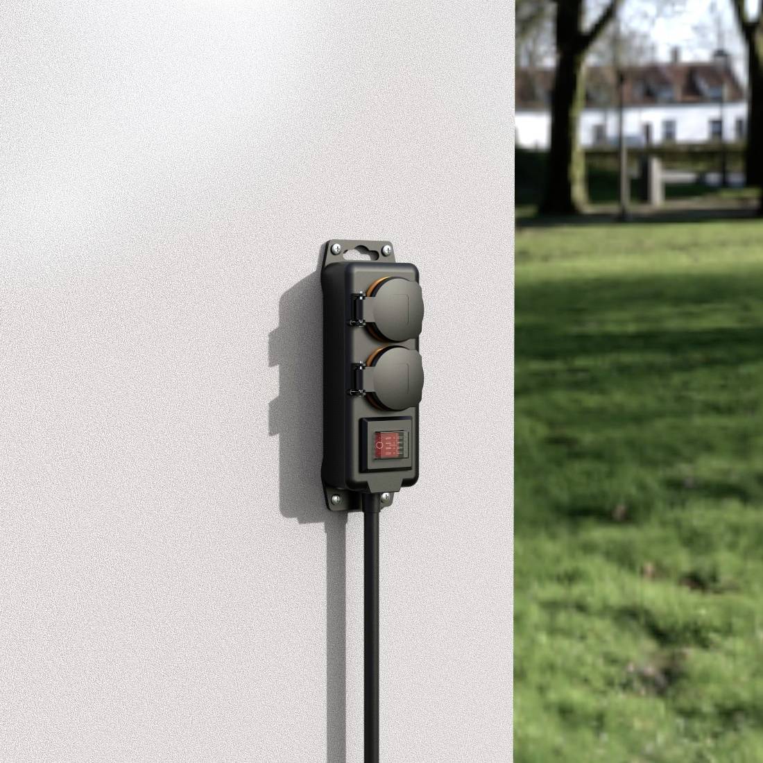 A outdoor socket on a white wall with two plug sockets and a digital display, with a green lawn in the background.