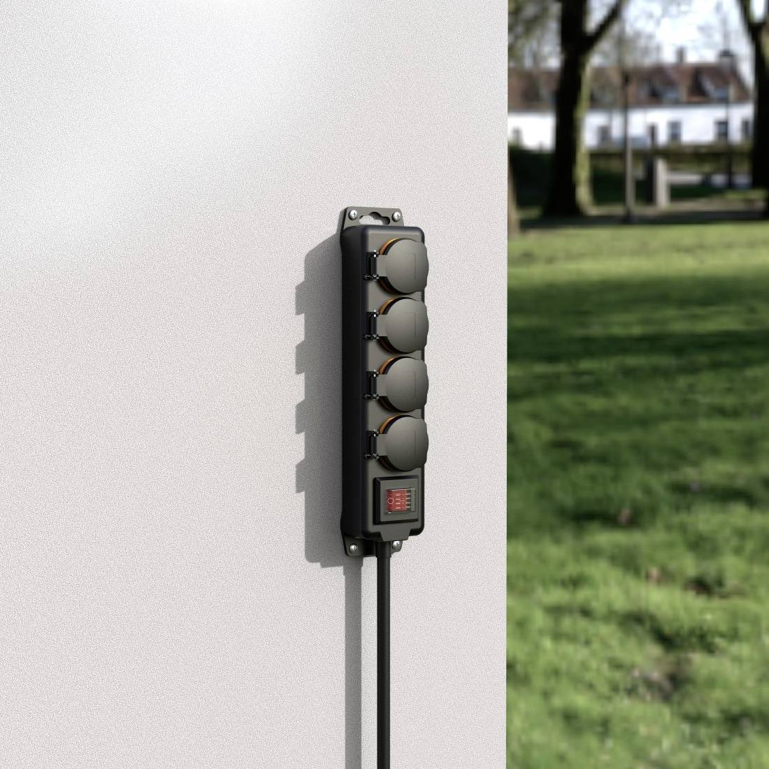 'Four-way socket on an exterior wall, with trees and grass in the background. The socket has protective covers.'