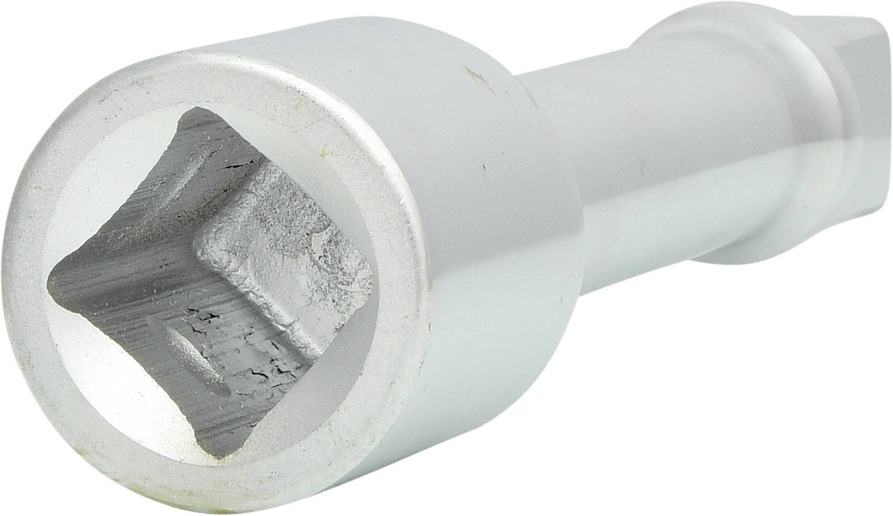 A silver metal tool, probably a socket attachment, lies at an angle. It has a square opening at one end.