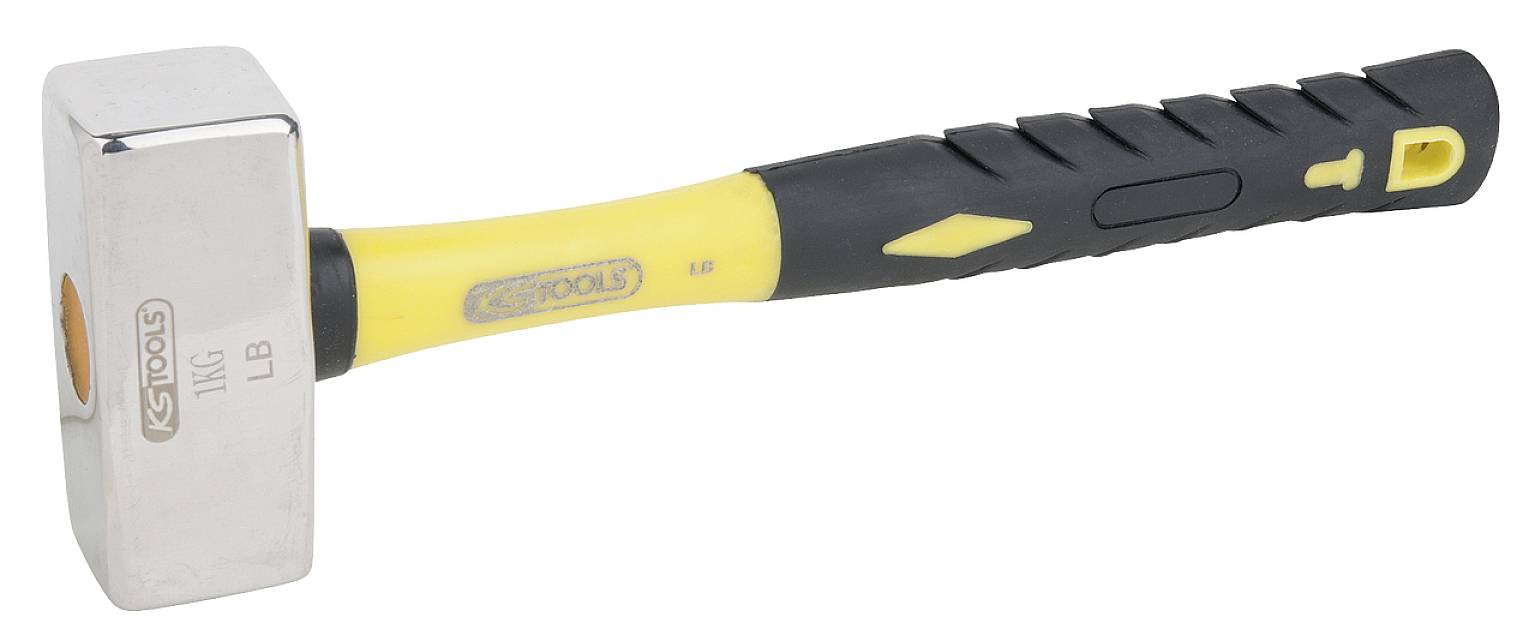 A sledgehammer with a yellow handle and black rubber grip. The head is metallic and angular. The tool brand is visible at the front.