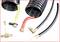 'Black twisted hoses with yellow and red markings, connected with brass fittings. Small white adapter parts are also visible.'