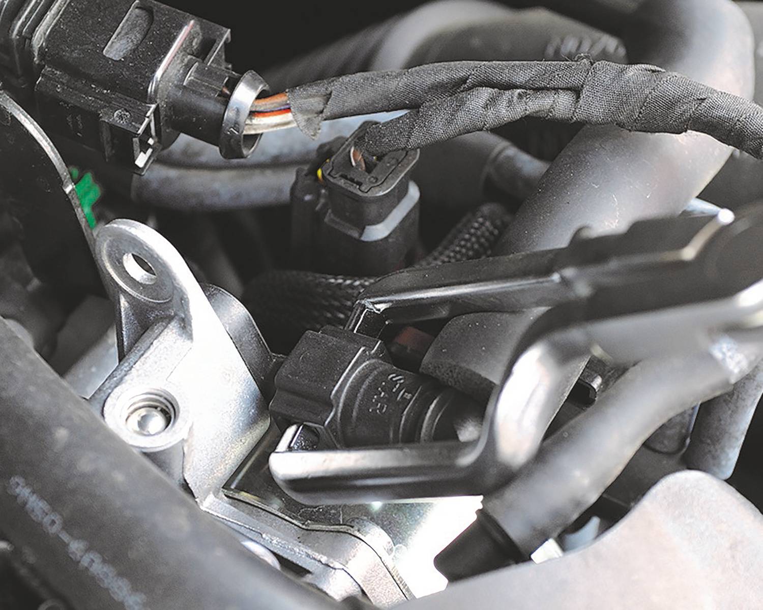 Close-up of a motor component with multiple cable connections and metal components. Demonstrates the complexity of automotive engineering.