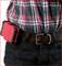 A person is wearing a checked shirt and a brown belt with a red toolbox attached to the belt.
