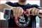 A person is holding a pneumatic tool and attaching a hose to it. Focus is on the hands and the tool.