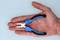 A hand is holding a small pair of pliers with blue-black handles, which are suitable for precision work.