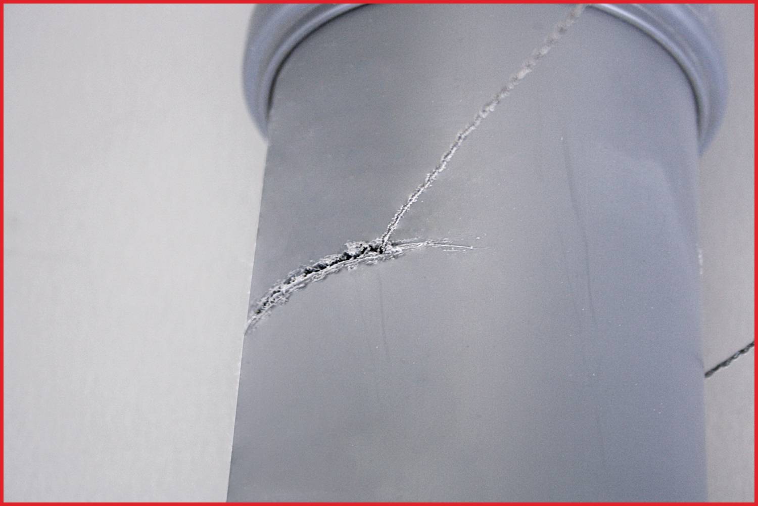 Crack in a grey pipe, close-up.