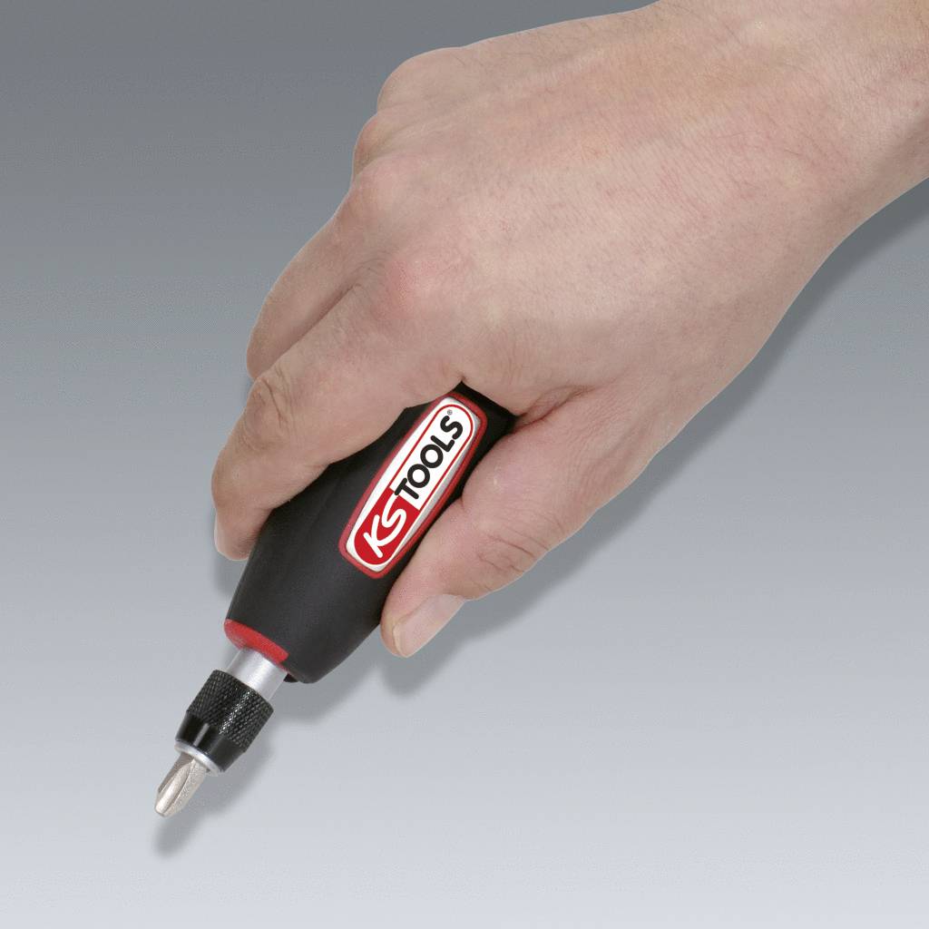 A hand is holding a screwdriver with a black handle and a silver bit. 'S-Tool' is printed on the handle. The background is neutral.