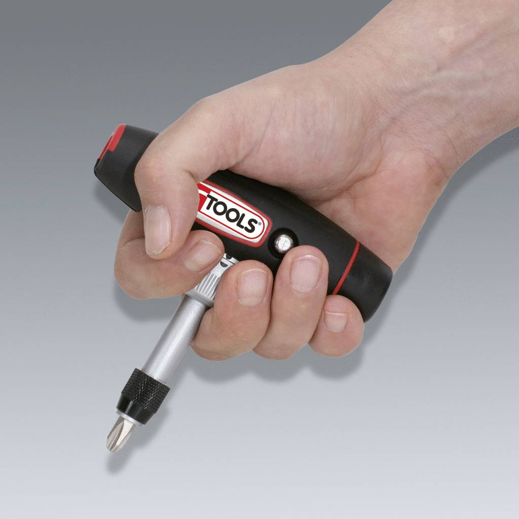 A hand is holding a small, black cordless screwdriver with a red accent. The label on the tool displays the word 'TOOLS'.