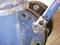 A spanner is used to tighten a bolt on a blue metal pipe. It demonstrates craftsmanship.