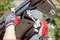 A person wearing gloves is using a spanner to remove a bolt at the rear of a car.