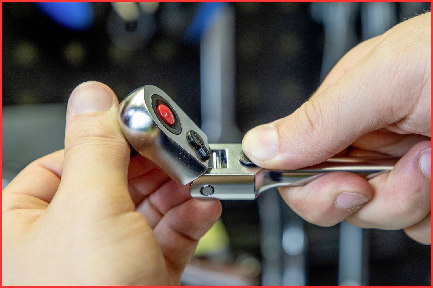 A person is holding a ratchet tool and adjusting it for use. Hands are in focus while they are setting the tool.