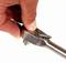 A hand holds a ratchet spanner and adjusts the direction lever.