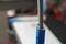 A blue pipe with a metal rod inside. The background is out of focus.