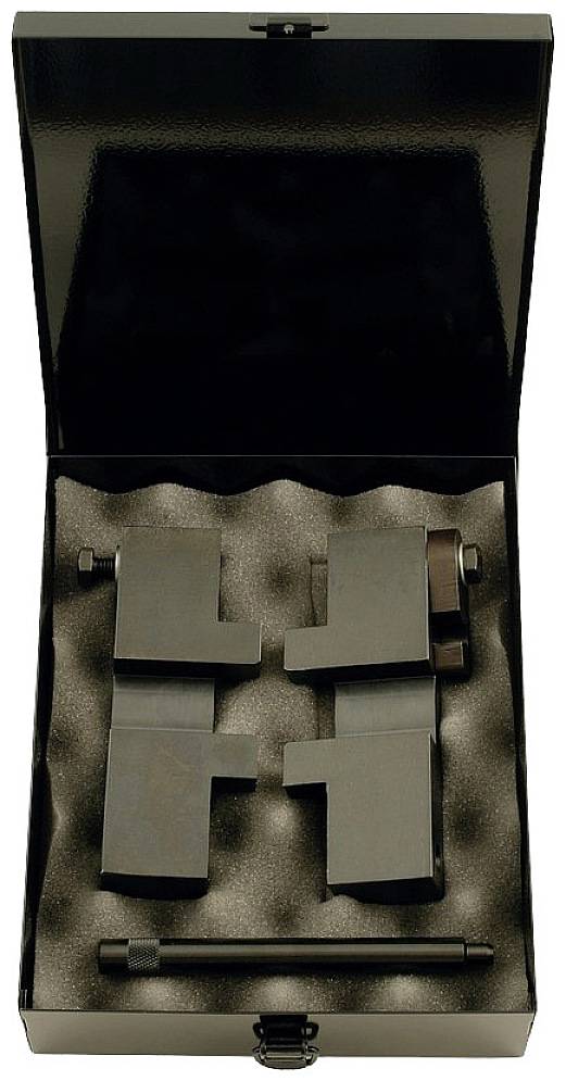 Metal box with foam lining, containing four black metal components of varying shapes and two round bars, potentially a tool.