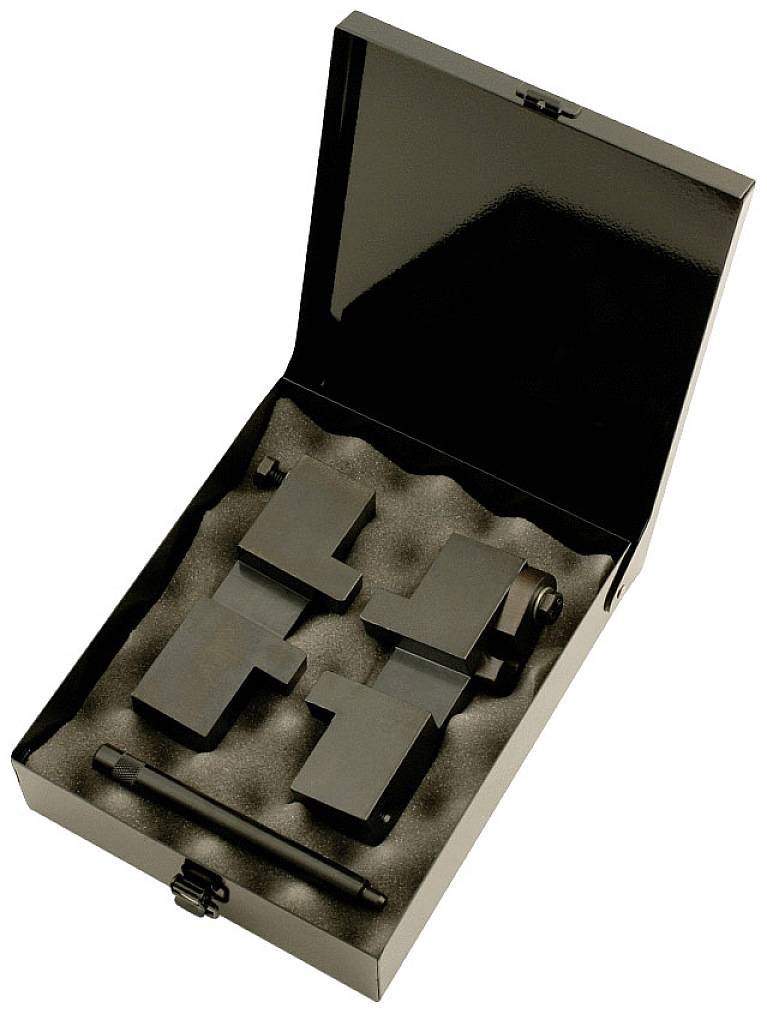 Open metal box lined with foam cushioning, containing specially shaped black metal components and a rod.