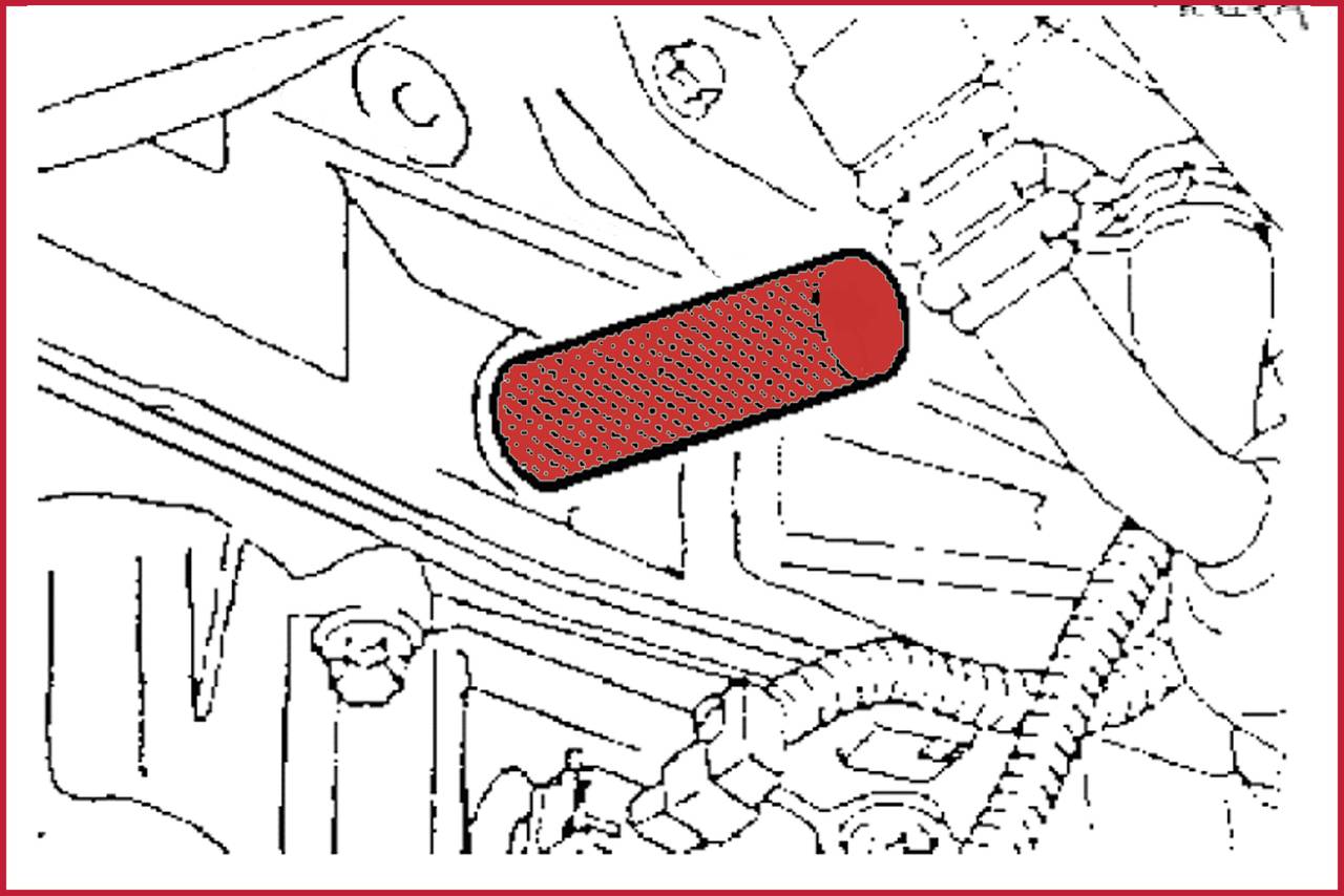 A red, cylindrical filter in a car engine system. Surrounding hoses and pipes are visible.